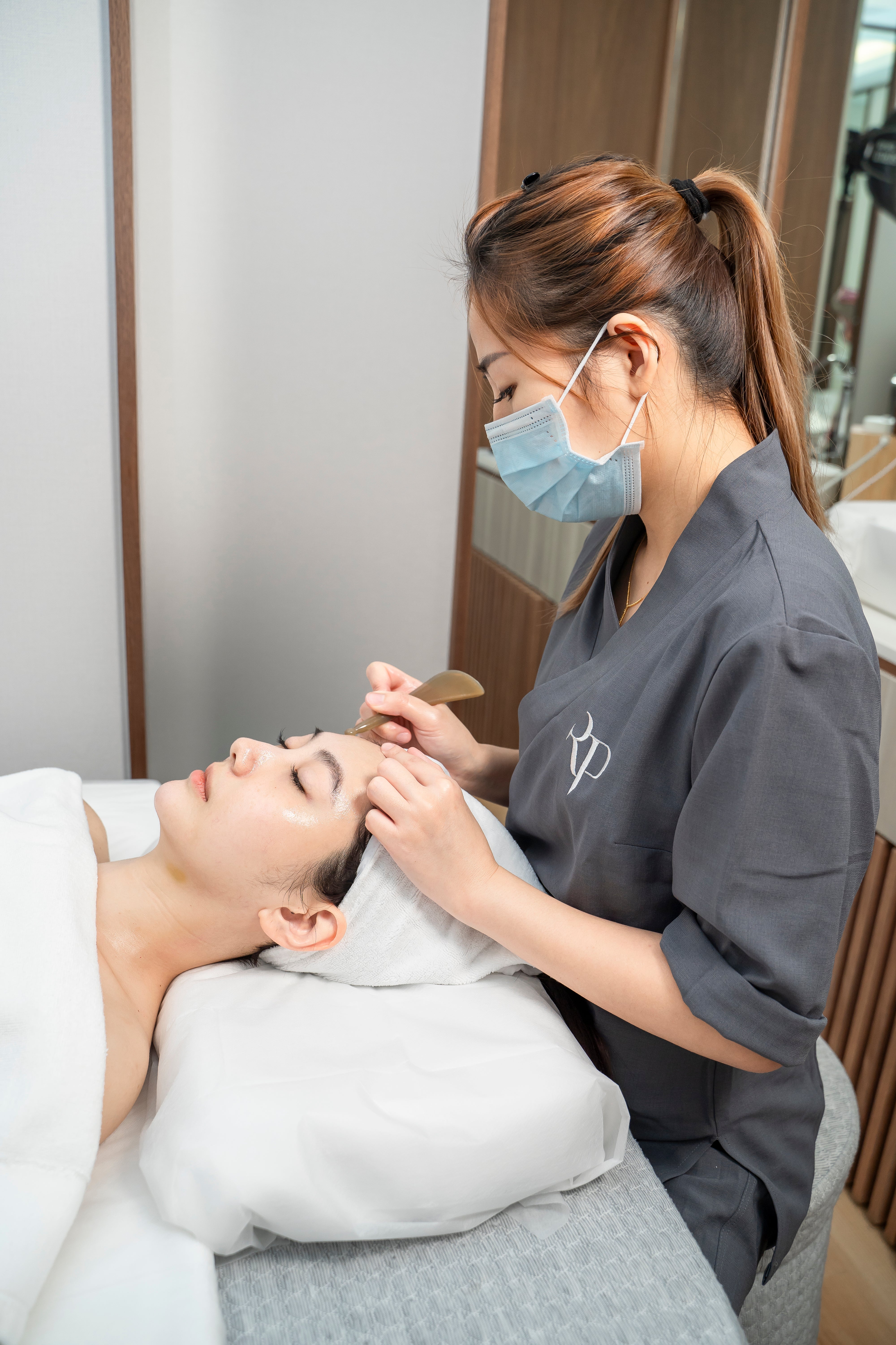 Person receiving a facial treatment from a professional in a spa setting.