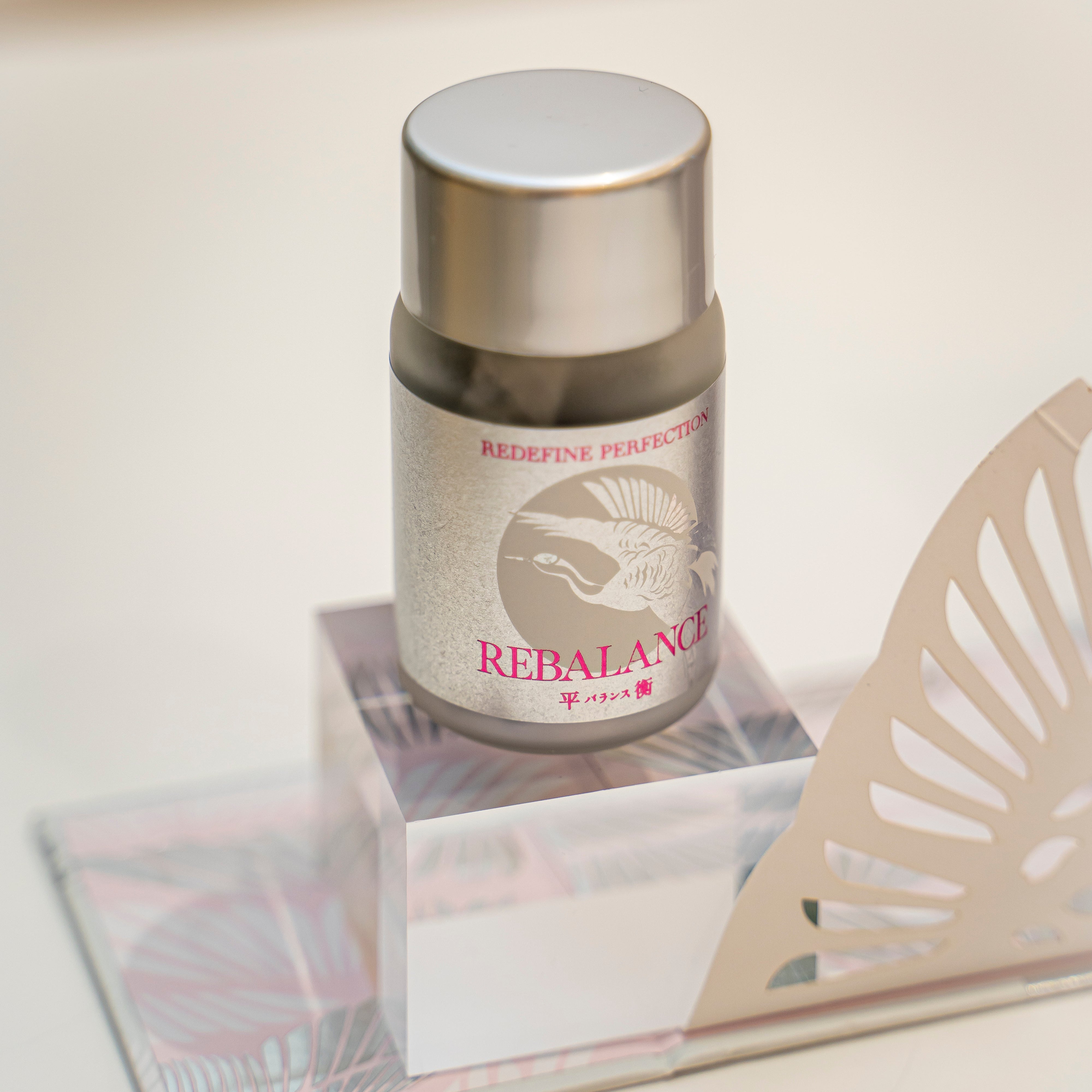 Cosmetic container labeled 'Rebalance' on a light surface