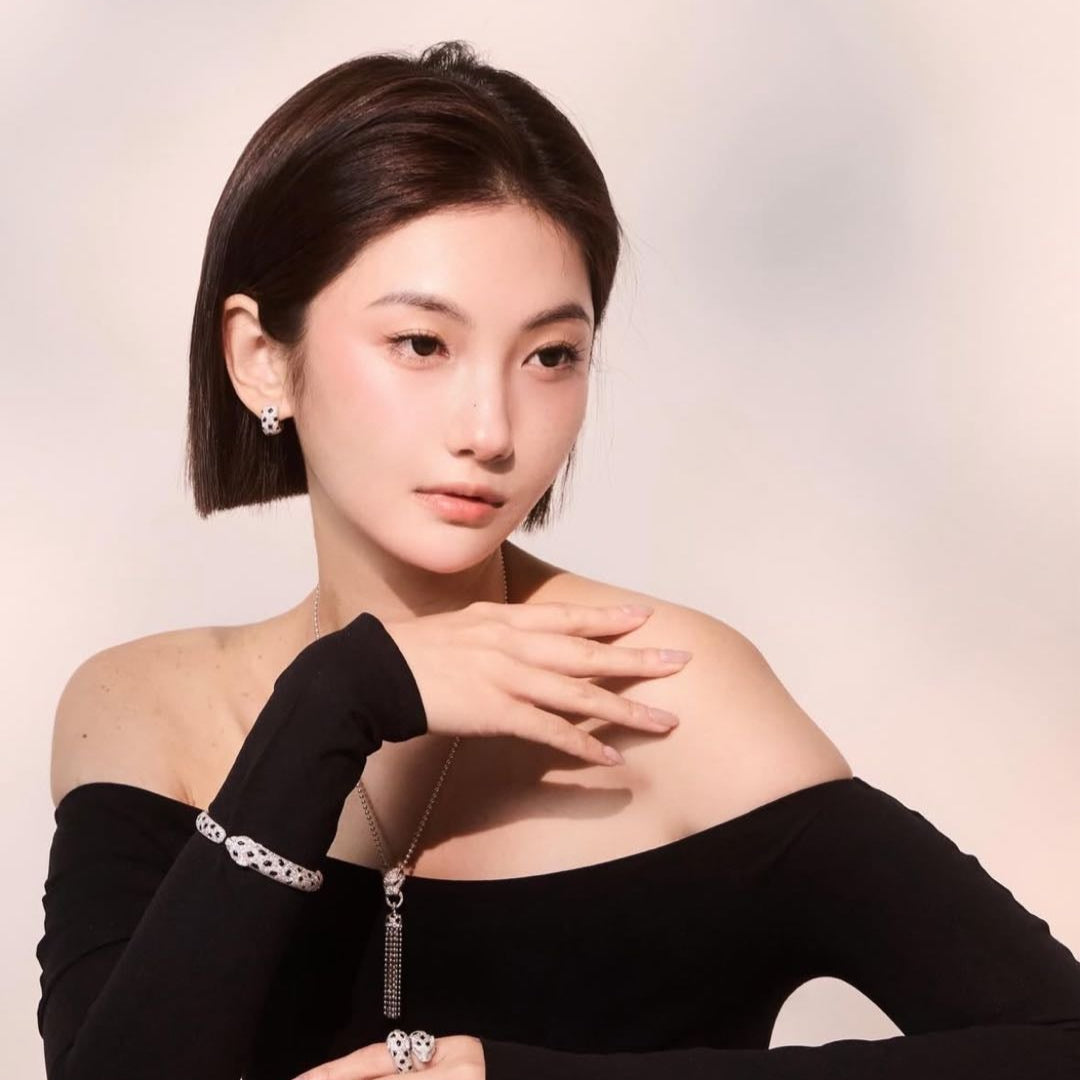 Woman wearing black off-shoulder top with zippers on a light gray background