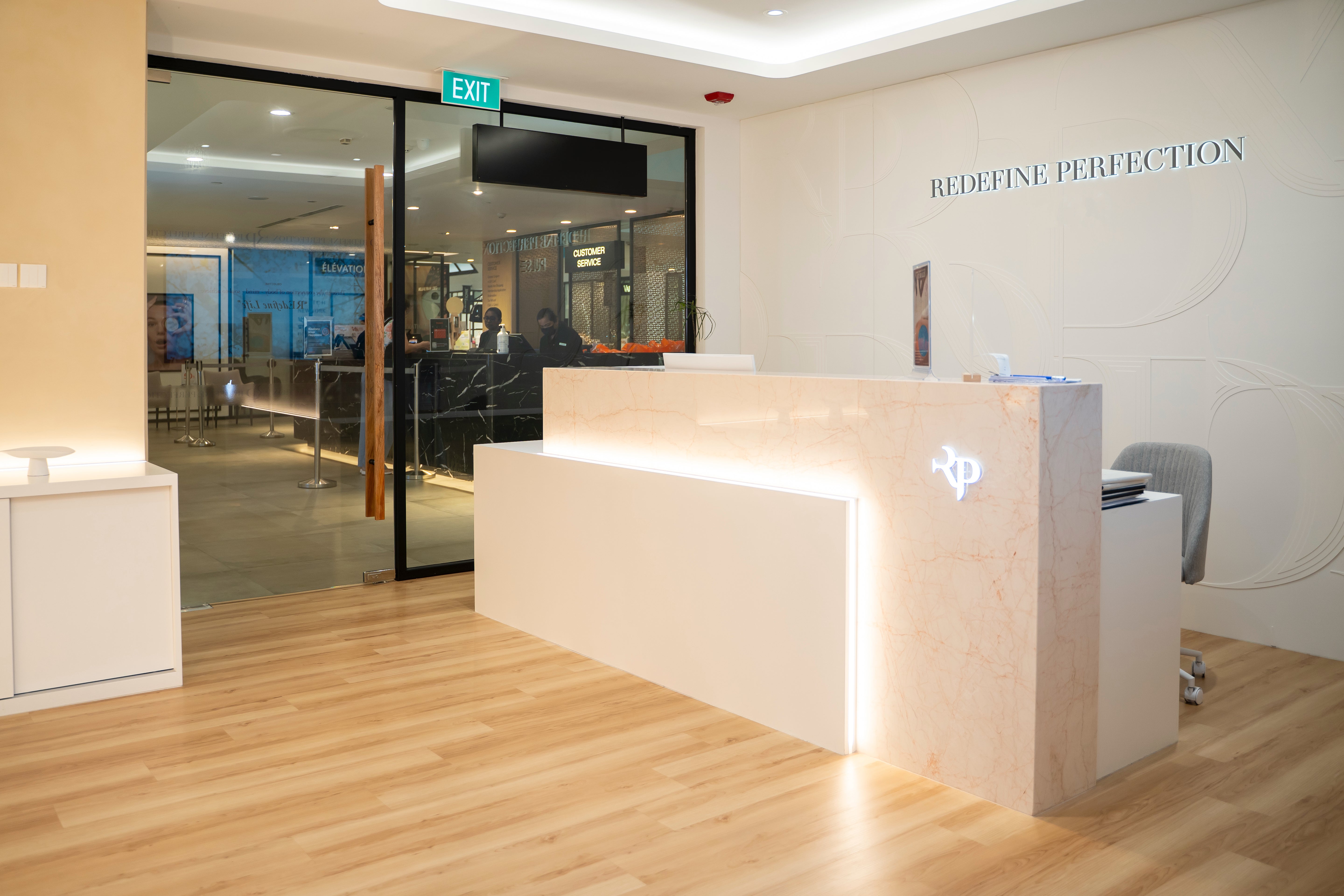 Modern reception desk in a professional setting with 'REDEFINE PERFECTION' on the wall.
