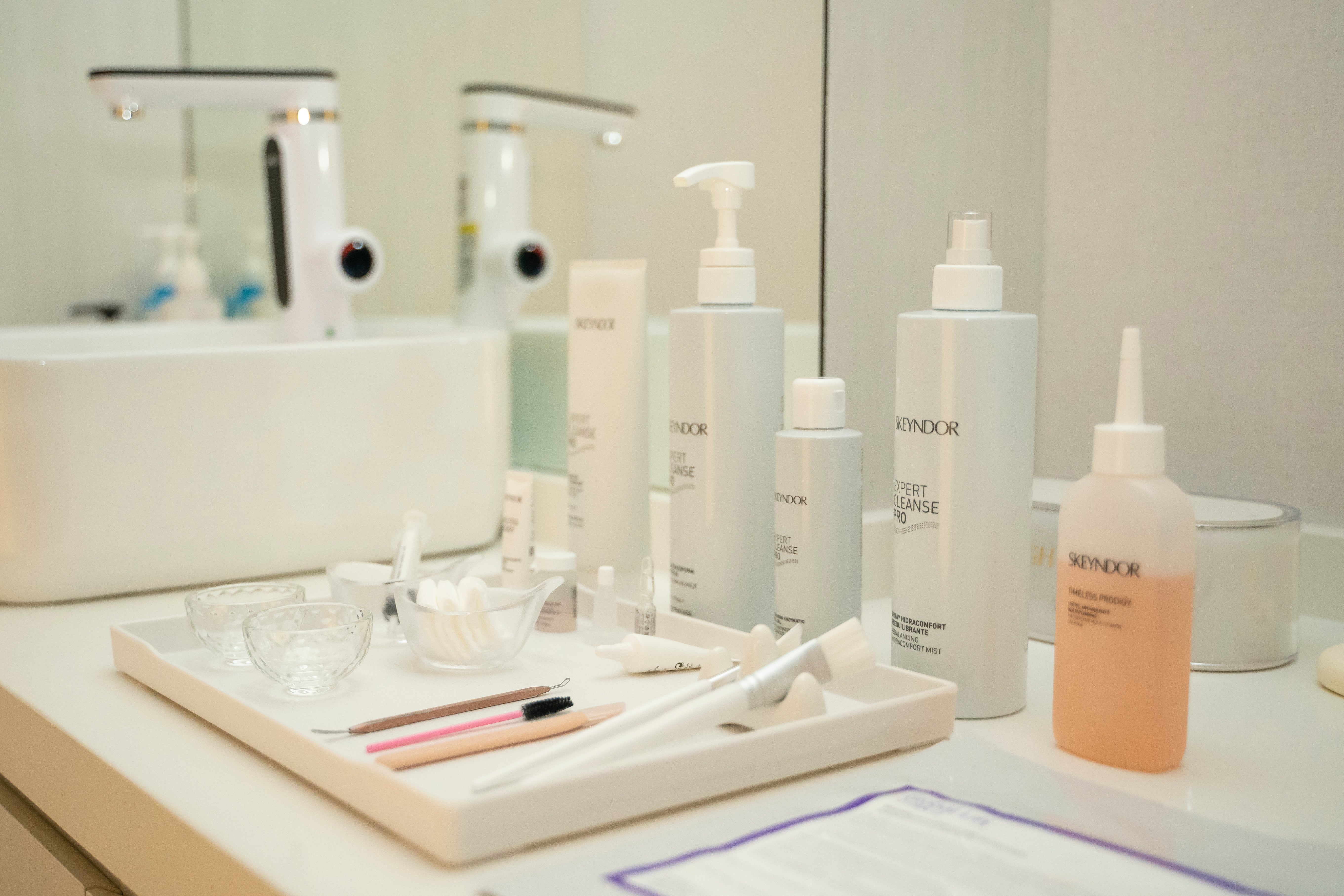 Cosmetic products on a tray with a mirror in the background