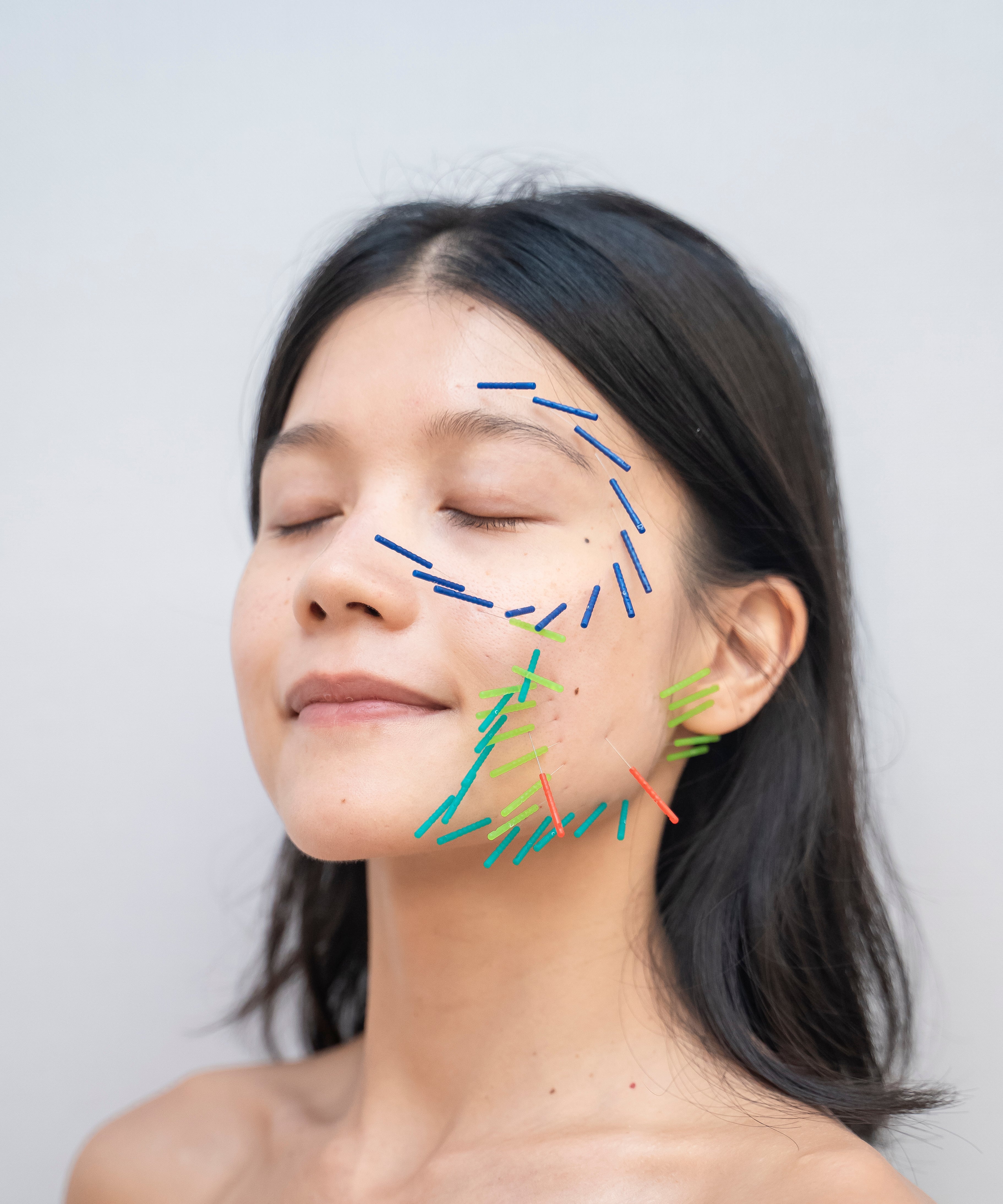 Woman with facial features highlighted by colorful lines on a plain background